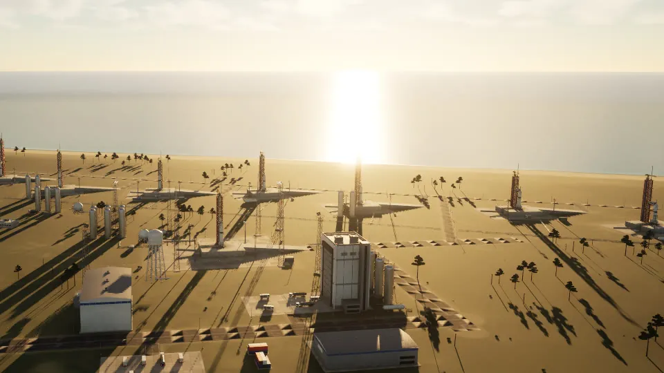 The launch site at golden hour, the sun low over the sea and long shadows across the pads.
